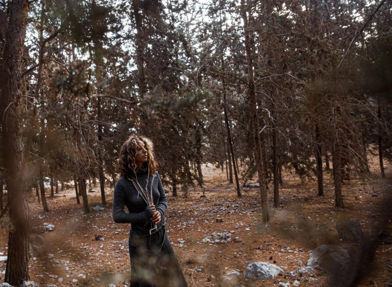A woman in a long dress walking mindfully in a forest