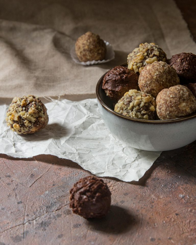 a bowl full of chocolate balls covered in nuts and coconut