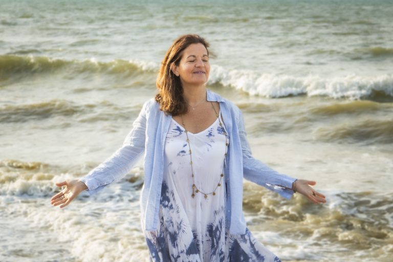 Nathalie with closed eyes and sprayed out arms looking content, happy and calm