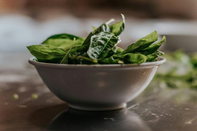 A white bowl filled with spinach leaves